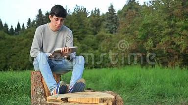 <strong>坐在公园里</strong>看书的年轻人